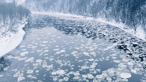 Winter river ice floe drifting, snow falling, aerial view Vidéo 101093887