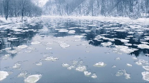 Winter river ice floe drifting, snow falling, aerial view 動画素材 101093889