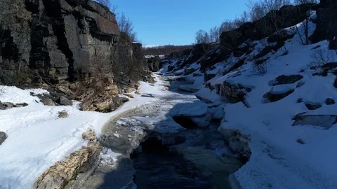 Winter river scene with snow, ice and water flowing. Drone flying forward Stock Footage 78736978