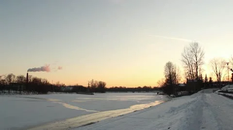 Winter river at sunset, with smoking chimney ProRes Stock Footage 10719882