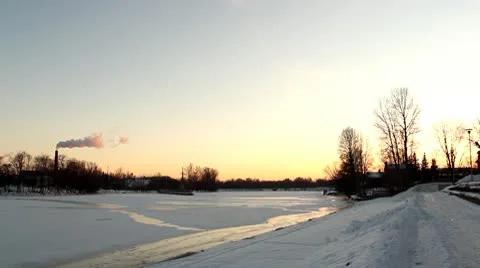 Winter river at sunset, with smoking chimney DNxHD Stock Footage 10737191