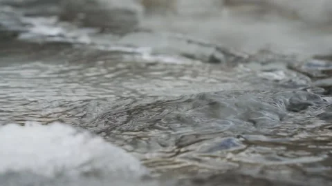 Winter river surface with water flowing over frozen ice, closeup detail Stock Footage 345431156