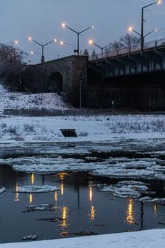 Winter river under bridge at dusk Stock Photos