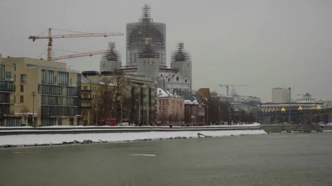 Winter Riverfront Cityscape With Cathedral Under Renovation, Bridge And Modern W Stockbeeldmateriaal 331237267