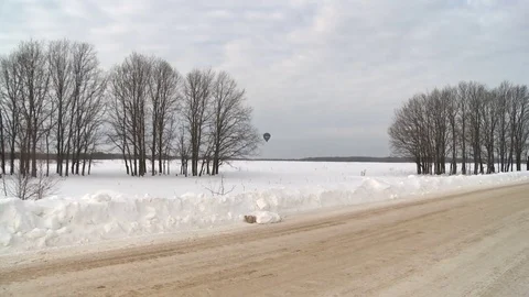 Winter road and ballon floating in the distance Stock Footage 73095484