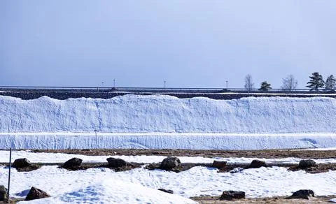 Winter road that has thawed with strange snow bank Stock Photos