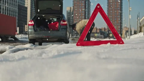 Winter road problem: man removes snow with shovel near stuck car while Stock Footage 331097270