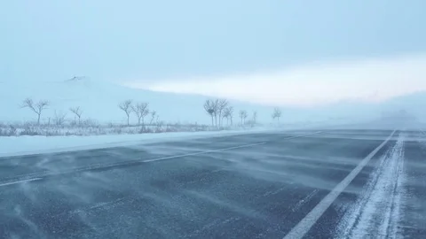 Winter road. Strong wind sweeps the snow on the road. Snowstorm. Stock Footage 72893177