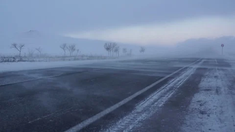Winter road. Strong wind sweeps the snow on the road. Snowstorm. Stock Footage 72893324