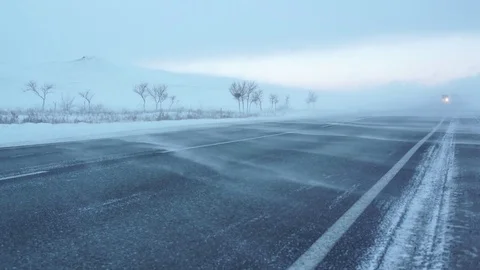 Winter road. Strong wind sweeps the snow on the road. Snowstorm. Video stock 72893444