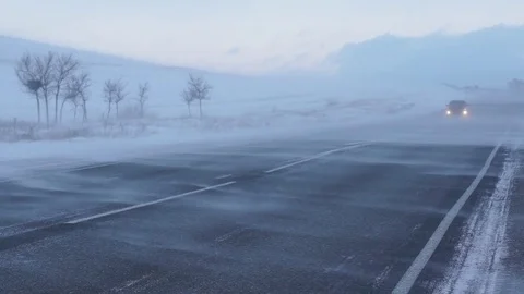 Winter road. Strong wind sweeps the snow on the road. Snowstorm.Slow motion. Stock Footage 72894077