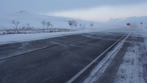 Winter road. Strong wind sweeps the snow on the road. Snowstorm. Stock Footage 72894520