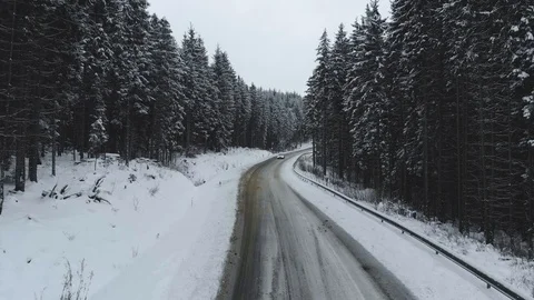 Winter road surrounded by snowy trees, a car goes to meet. Stock Footage 121208452