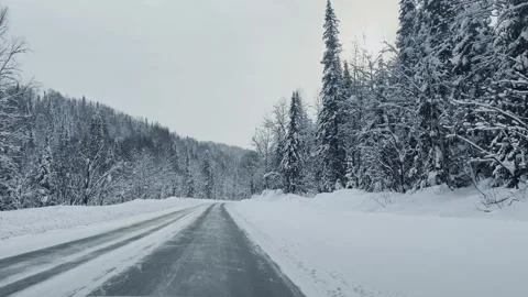 Winter road with trees covered in snow. Driving a car on a snowy highway. Видео 321423454