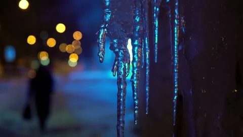 Winter Russian evening. Icicles melt from warm air, neon light in the background Stock Footage 146406637