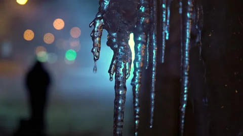 Winter Russian evening. Icicles melt from warm air, neon light in the background Stock Footage 146407694