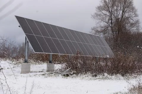 Winter scene of array of solar panels in rural environment Foto stock