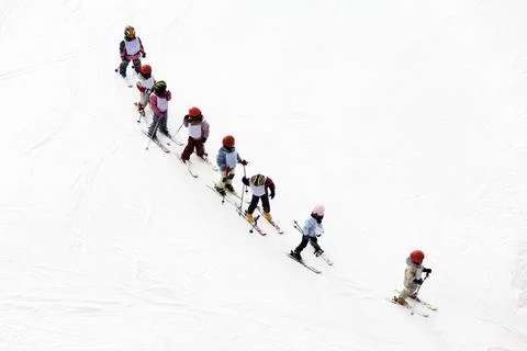 Winter scene: kids learning to ski and their instructor Stock Photos