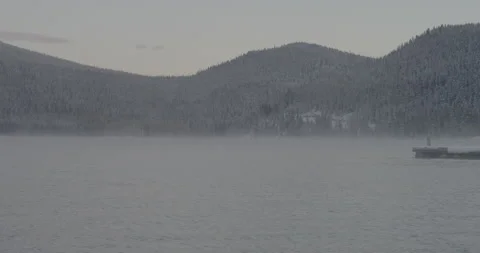 Winter scene of a lake and a pine tree forest covered with snow Video stock 150490567