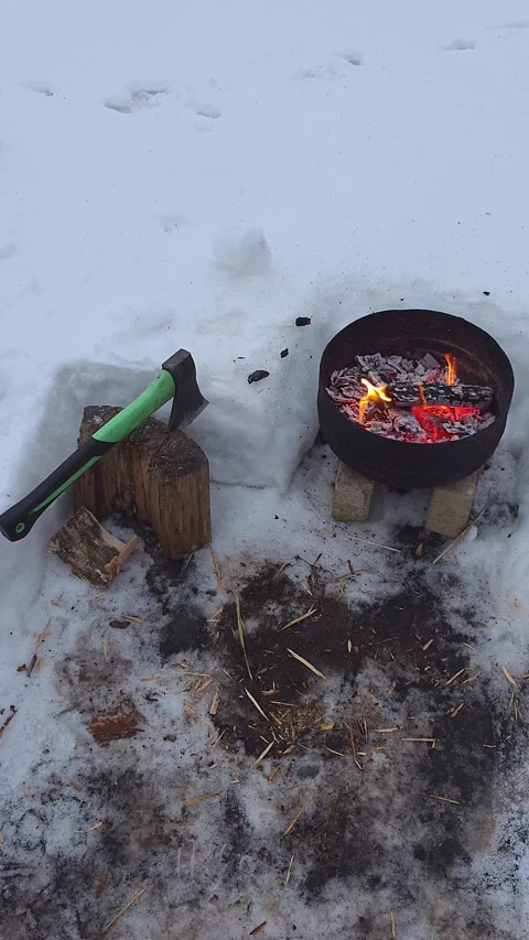 Winter scene with a small campfire burning in a black metal bowl on snow-co.. Vídeo Stock 333790697
