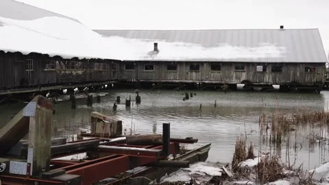 Winter Scene of a Snow-Capped Dockside Barn and Tugboat Stock Footage 271199553