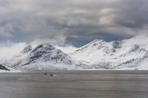 Winter seascape with snow, mountains, sea and two boats Stock Photos