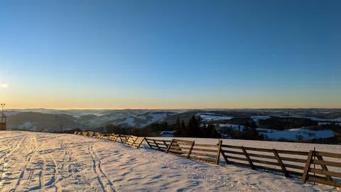 Winter ski slope with sunset over snowy mountains. Foto stock