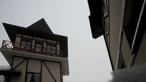 The winter sky and snow falling on the background of the roof of a vintage house Stock Footage 87087708