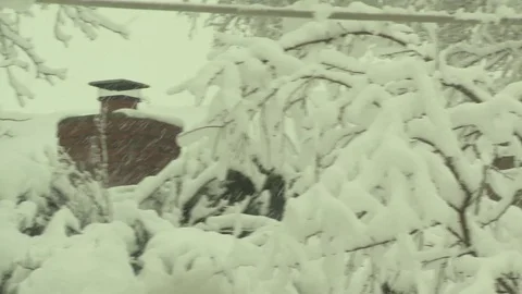 Winter snow piles up on chimney trees power lines Stock Footage 101140477