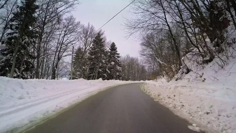 Winter snow vehicle drive POV narrow road car travel village houses cloudy sky Stock Footage