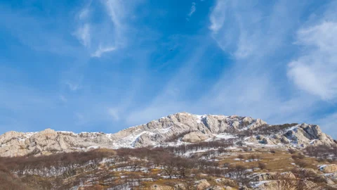 Winter snowbound mountains under a cloudy sky Stock Footage 328711594