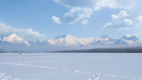 Winter snowbound plain before a mountain chain Stock Footage 262443057
