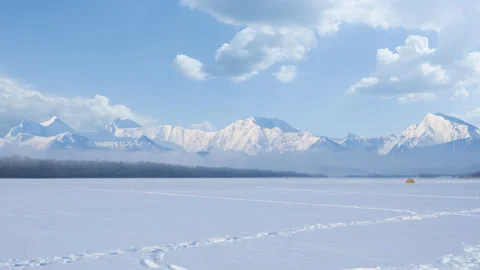 Winter snowbound plain before a mountain chain Stock Footage 311506809