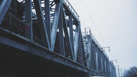 Winter snowfall on the background of the railway bridge on the river Stock Footage 99591191