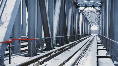 Winter snowfall on the background of the railway bridge on the river Video stock 99591502