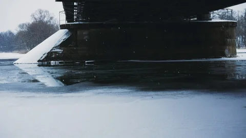 Winter snowfall on the background of the railway bridge on the river Video stock 99591571