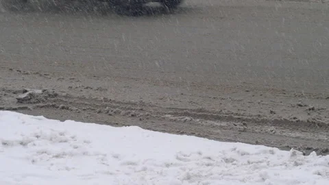 Winter snowfall road with passing vehicles in slush on the roads. melting snow o Stockbeeldmateriaal 220613650