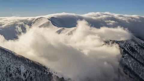 Winter snowy mountains low clouds flying over ridge in morning light time lapse Stock Footage 70216592