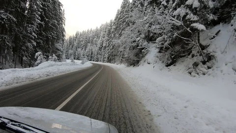 Winter, snowy road in the middle of the forest, car travel, hood, turn. Stock Footage 117346830