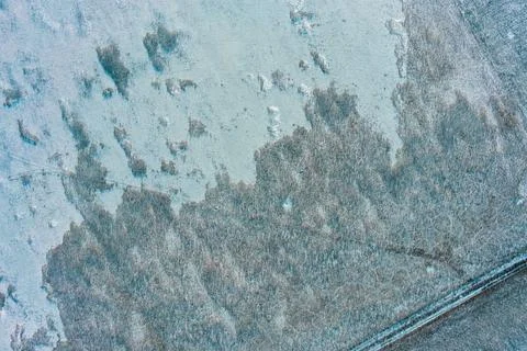 Winter steppe texture with dry grass patches and snow covered abandoned field 写真素材