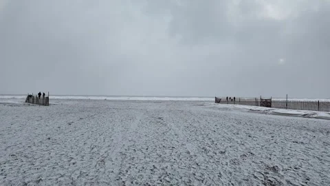 Winter Strolls on a Snowy Beach With Distant Figures Stock Footage 301129658
