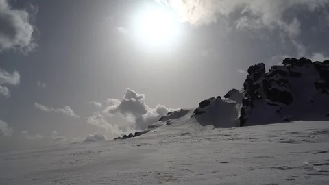 Winter Sun and Clouds Over Snowy Mountain 4K Stock Footage 76517328