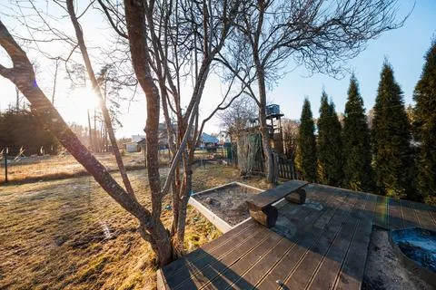 Winter sun on backyard deck with arborvitae and play tower Stock Photos