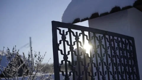 The winter sun shines through the iron fence Stock Footage 239358185
