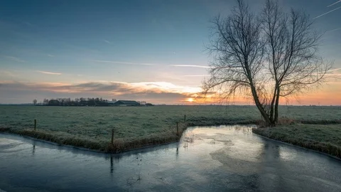 Winter sunrise with frozen ditch in the pasture. Stock Footage