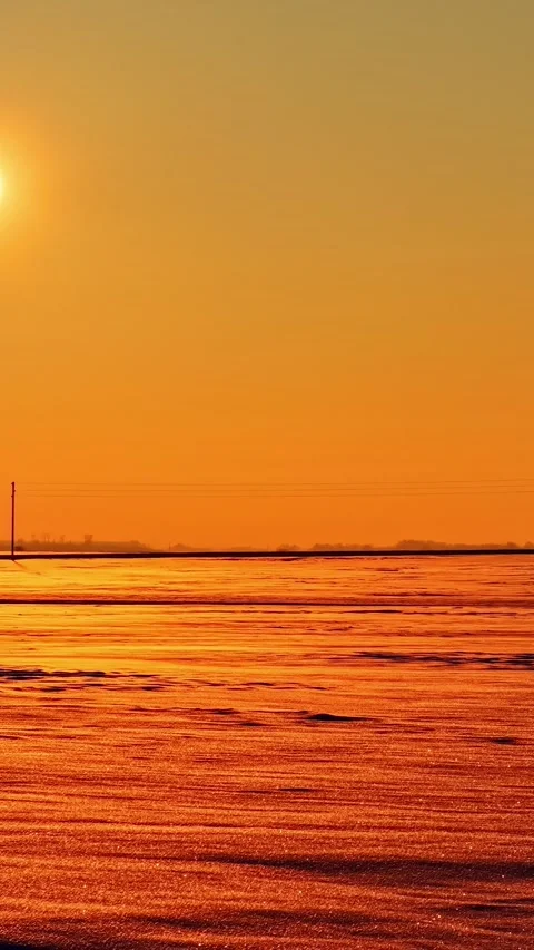 Winter Sunset Above Snow Covered Fields Beneath Glowing Orange Sky Stock Footage 339039888