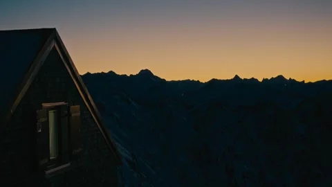 Winter Sunset Cabin Perched on a Rugged Snowy Mountain Range at Dusk 库存影片 331170335
