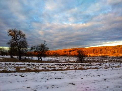 Winter Sunset Casting Warm Glow on Snow-Covered Land Stock Photos