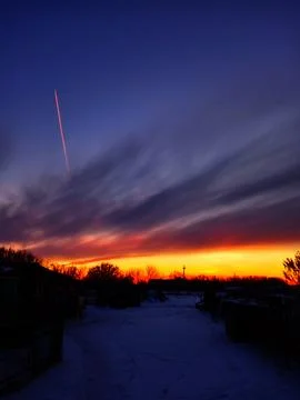 Winter Sunset with Contrail and Dramatic Sky" Stock Photos