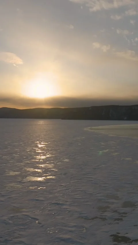 Winter sunset drone view of Angara River meeting Lake Baikal near Listvyanka Stock Footage 346557077
